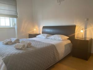 een slaapkamer met een bed met handdoeken erop bij TEJO HOUSE RIVER Lisbon (Cacilhas) in Almada