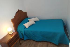 a bedroom with a blue bed with a night stand and a lamp at Una llar amb vista a L'Ampolla in L'Ampolla +4 photos