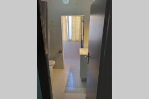 a bathroom with a toilet and a door to a hallway at Una llar amb vista a L'Ampolla in L'Ampolla