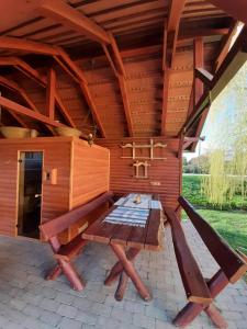 Magyarszerdahely的住宿－Márfi vendégház，一个带桌子和长凳的大型木制庭院