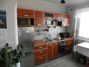 a kitchen with wooden cabinets and a stainless steel refrigerator at Sopot apartament z widokiem na Morze in Sopot