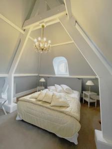 a bedroom with a large bed with an attic at Château de Noyelles – Baie de Somme in Noyelles-sur-Mer