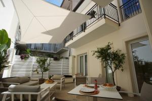 d'une terrasse avec une table et des chaises. dans l'établissement Palazzo Bibbi - Rooms to Live, à Reggio de Calabre