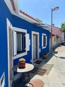 un edificio blu con un tavolo di fronte di Casa do Chinelo Azul a Queluz