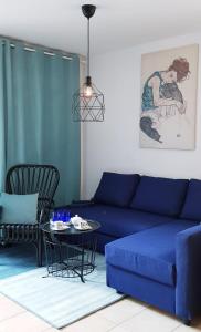 a living room with a blue couch and a table at 7 LAKES apartment in Bohinj