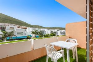 balkon z białym stołem i 2 krzesłami w obiekcie Apartamento Los Seres 212 w mieście Los Cristianos