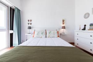 a white bedroom with a large bed and a window at Amazing Sesimbra Duplex close to the beach by Trip2Portugal in Sesimbra