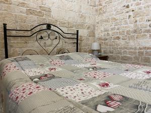 a bed with a quilt with hearts on it at Trullo Zia Nina in Alberobello