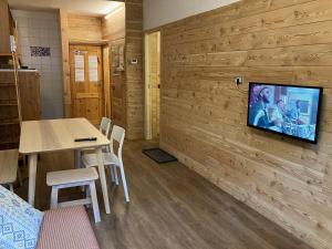 Zimmer mit einem Tisch und einem TV an der Wand in der Unterkunft House Cervinia Apartments in Breuil-Cervinia
