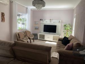 salon z 2 kanapami i telewizorem z płaskim ekranem w obiekcie CASA FAMILIAR “SANTA PAZ” w mieście Aparecida