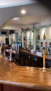 un bar con barra de madera en una habitación en The Plough Inn Wigston, en Wigston Magna