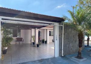 a patio with awning and a palm tree at CASA FAMILIAR “SANTA PAZ” in Aparecida