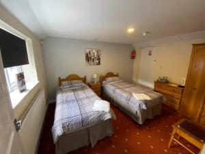 Un dormitorio con dos camas y una ventana. en The Plough Inn Wigston, en Wigston Magna 8 fotos más