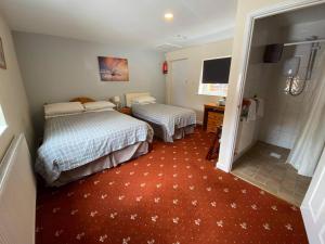 1 dormitorio con 2 camas y alfombra roja en The Plough Inn Wigston, en Wigston Magna
