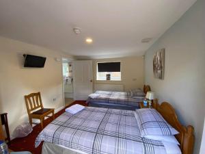 1 dormitorio con 2 camas individuales y TV en The Plough Inn Wigston, en Wigston Magna