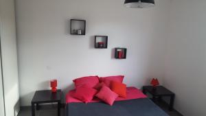 a bedroom with a bed with red pillows at villa l atlantide in Vieux-Boucau-les-Bains
