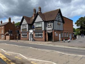 un edificio blanco y negro en la esquina de una calle en The Plough Inn Wigston, en Wigston Magna
