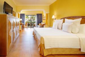 a bedroom with a large bed and a living room at Barceló Maya Colonial - All Inclusive in Xpu Ha
