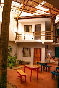 uma sala com mesas e bancos em frente a um edifício em Maré Mansa Pousada e Hostel em Itacaré