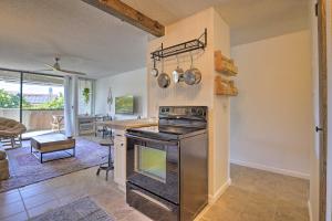 a kitchen with an oven and a living room at Big Island Condo with Pool Access 1 Mi to Beach! in Kailua-Kona