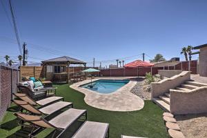 un patio trasero con piscina, sillas de césped y piscina en Updated Home with Outdoor Oasis, 2 Mi to Lake! en Lake Havasu City