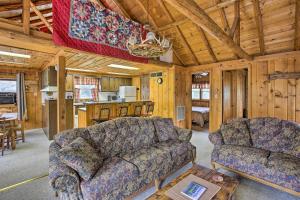 sala de estar con sofá y mesa en Rustic River View Cabin with Fire Pit, Games and Grill en Houghton Lake