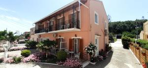 a pink building with flowers in front of it at Apartments Elena in Kavos