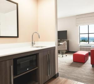 a kitchen with a sink and a large mirror at Snoqualmie Inn by Hotel America in Snoqualmie