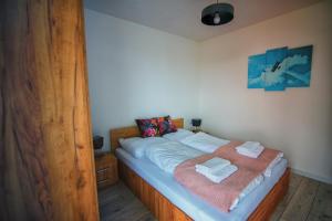 a bed with two towels on it in a room at Blue Sky - Apartamenty Zator in Zator