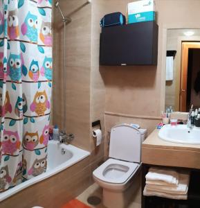 La salle de bains est pourvue de toilettes, d'un lavabo et d'un rideau de douche. dans l'établissement On the beach! Frente al Paseo Marítimo, Parking y Piscina, à Malaga