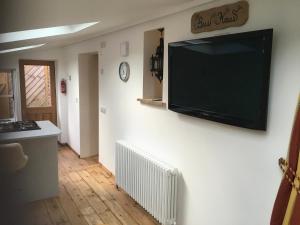 TV de pantalla plana colgada en la pared en The Bees Knees @ Redhill Grange, en Monmouth