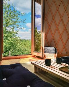 ReguliceにあるLushHills - Stylowa i Naturalna Jurtaのソファと大きな窓が備わる客室です。