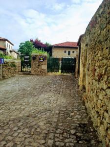 un callejón con una pared de piedra y una valla en Albergue Gándara, en Santillana del Mar