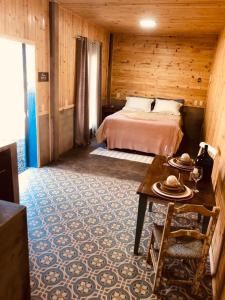 a bedroom with a bed and a table in a room at Ap. Shalom. Pousada Colina dos Ventos in Urubici