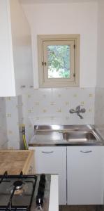 uma pequena cozinha com um lavatório e uma janela em Agriturismo Vignavecchia em Vignacastrisi