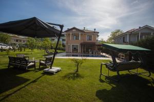 un cortile con sedie e ombrellone e una casa di Fairy tale house villa sapanca a Sapanca