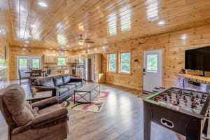 a living room with a pool table and a tv at Hilltop Cabin in Bryson City
