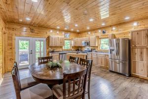 a kitchen with a table and chairs and a refrigerator at Hilltop Cabin in Bryson City