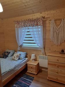a bedroom with a bed and a window at Domki przy jeziorze Wejsuny in Ruciane-Nida