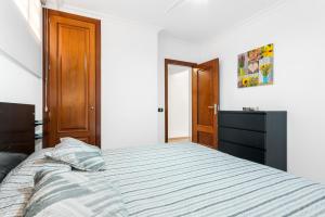 sypialnia z dużym łóżkiem i komodą w obiekcie Apartamento Los Seres 212 w mieście Los Cristianos