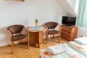 a room with a table and two chairs and a tv at Dom Gościnny Zielono Mi in Pobierowo