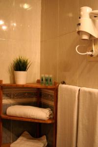 a bathroom with a towel rack and towels at Pensi&oacute;n Arg&uuml;elles in Ribadesella