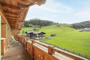 Ferienwohnung "Mein Alpenjuwel" في فيلزموس: بلكونة منزل مطلة على حقل أخضر