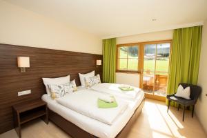 a bedroom with a large white bed and a window at Ferienwohnung "Mein Alpenjuwel" in Filzmoos