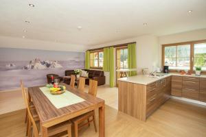 a kitchen and living room with a table and chairs at Ferienwohnung "Mein Alpenjuwel" in Filzmoos