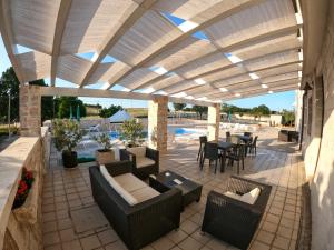 un patio con divani, tavolo e sedie di B&B Il Leccio ad Alberobello