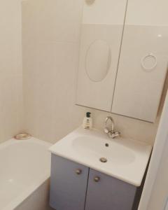 W łazience znajduje się umywalka i lustro. w obiekcie Le 2 w mieście Balaruc-les-Bains