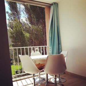 stół i krzesła na balkonie z oknem w obiekcie Le 2 w mieście Balaruc-les-Bains