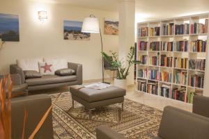 a living room with a book shelf filled with books at Hotel Corallo in Albinia