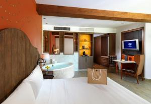 a bedroom with a bed and a bathroom with a tub at Hard Rock Hotel Riviera Maya - Hacienda All Inclusive in Puerto Aventuras